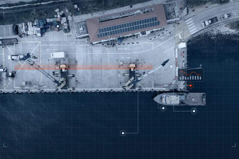 Aerial view of a working quay with cranes, cargo and a vessel alongside